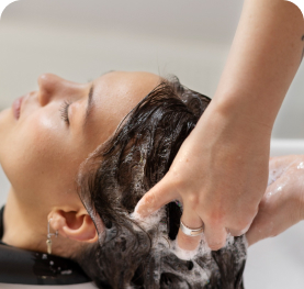 A professional stylist providing hair care treatment at a salon