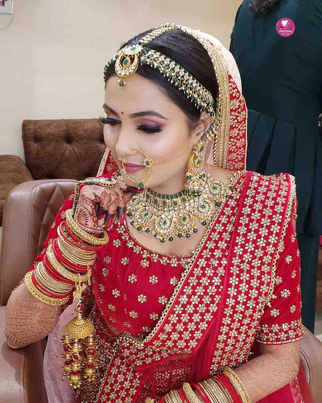 A stunning Indian bride in a traditional red lehenga with intricate gold embroidery, showcasing the best Indian bridal look.
