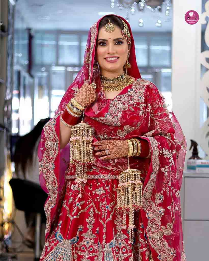 Indian bride in traditional attire with intricate jewelry and makeup, showcasing a classic bridal look.