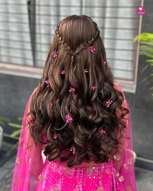 A stylish woman showcasing a glamorous party hairstyle with soft curls and elegant accessories.