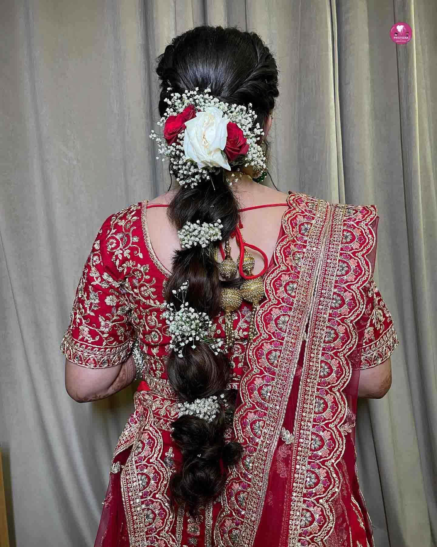 Traditional South Indian bridal hairstyle adorned with flowers and gold accessories.