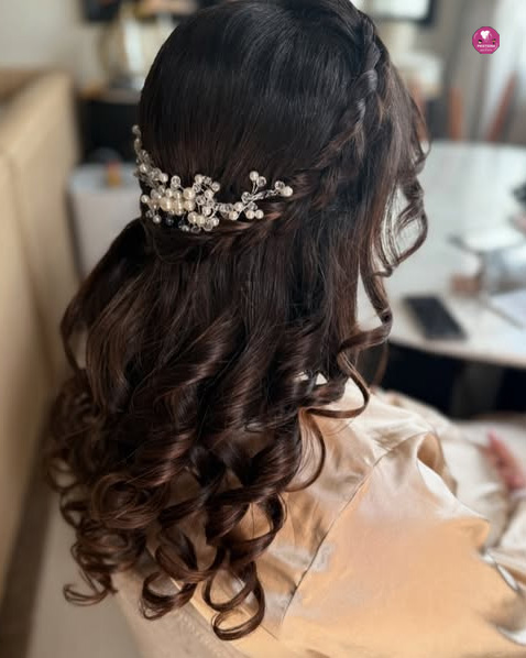 A woman wearing a traditional South Indian party hairstyle in Dubai, adorned with jasmine flowers and gold hair accessories.