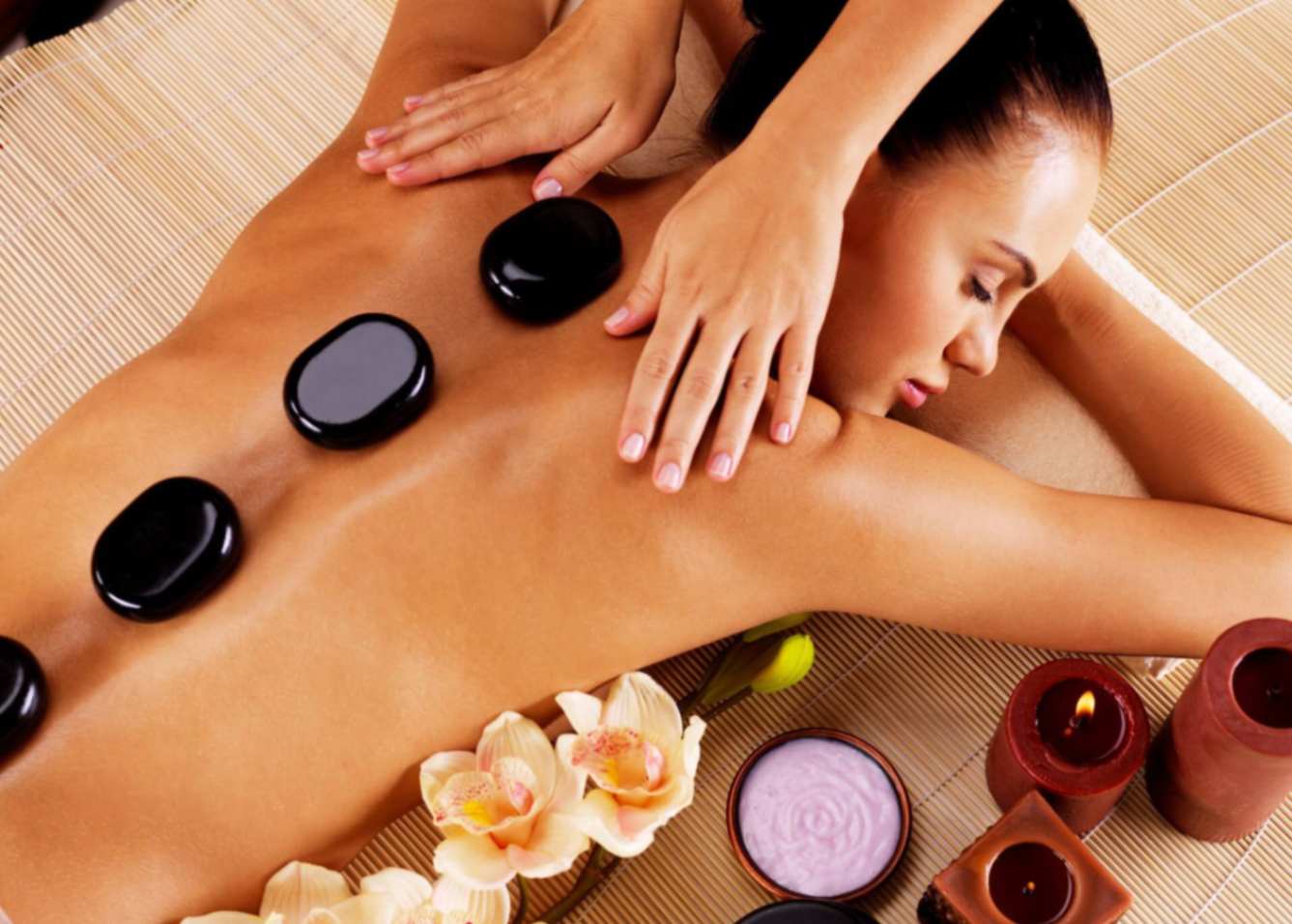 A female client enjoying a hot stone massage in Dubai.