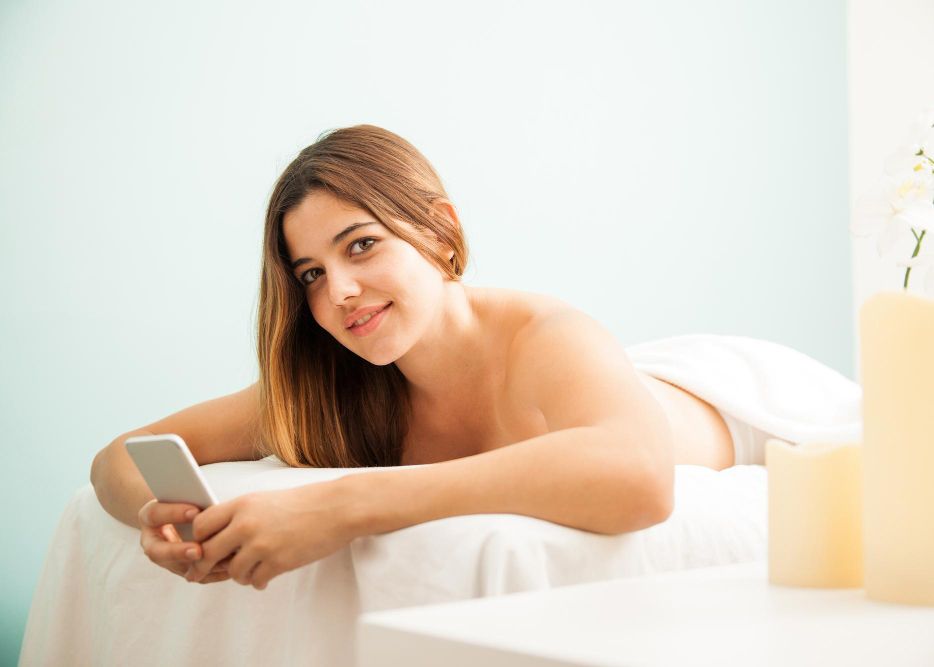 a female enjoing massage while using her moble