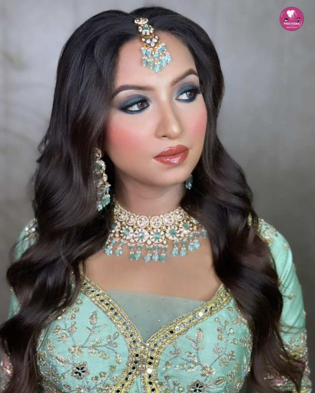 A professional makeup artist applying glamorous party makeup to a woman in a beauty studio in Sharjah.