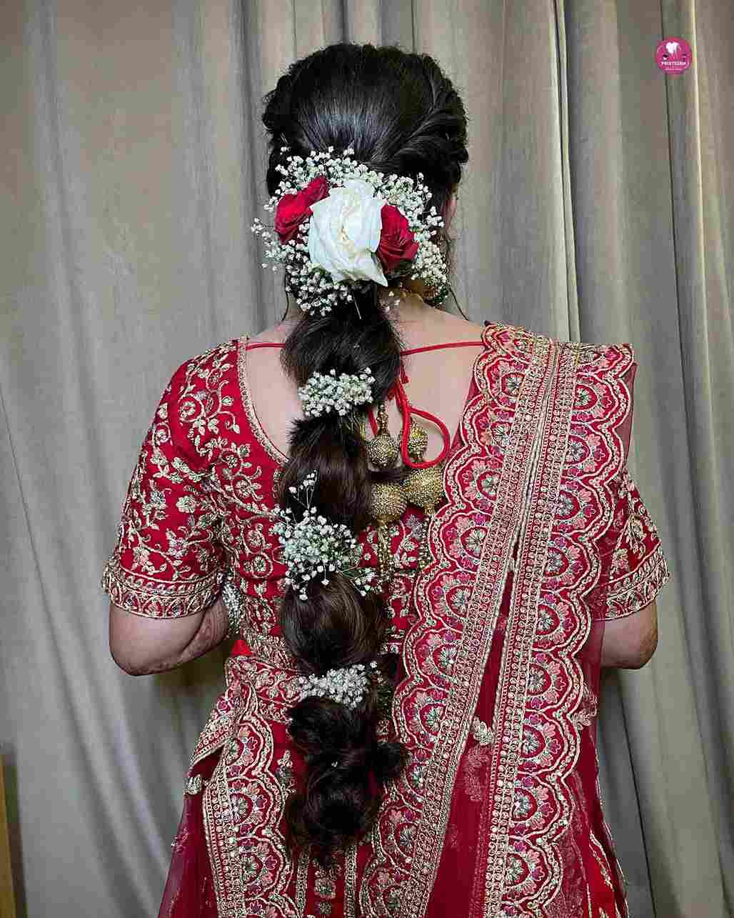 Traditional South Indian bridal hairstyle adorned with flowers and gold accessories.